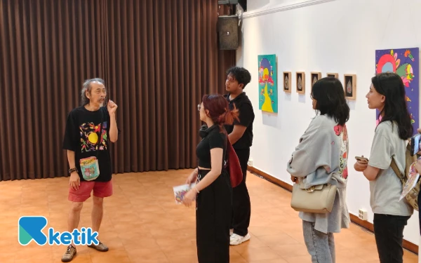 Foto Daniel Kho (depan kiri) menjelaskan pameran lukisan La Wet kepada pengunjung di Wisma Jerman, Selasa 24 Juni 2025. (Foto: Fitra/Ketik)