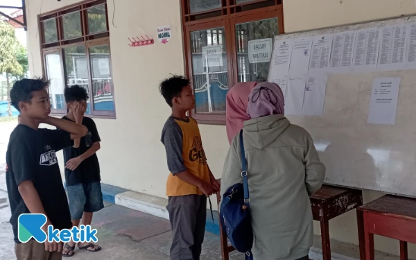 Foto Sejumlah orang tua bersama anaknya melihat hasil pengumuman penerimaan siswa baru di SMPN 1 Ampelgading, Sabtu, 28 Juni 2025. (Foto: Slamet/Ketik)