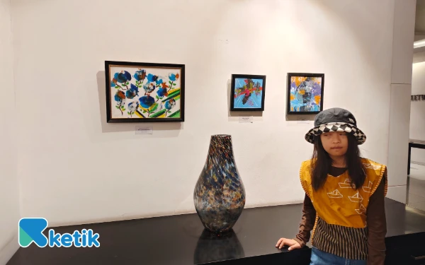 Foto Davina anak istimewa down syndrome menunjukkan hasil karya lukisannya di pameran Infinite Color, Jumat, Juli 2025. (Foto: Fitra/Ketik)