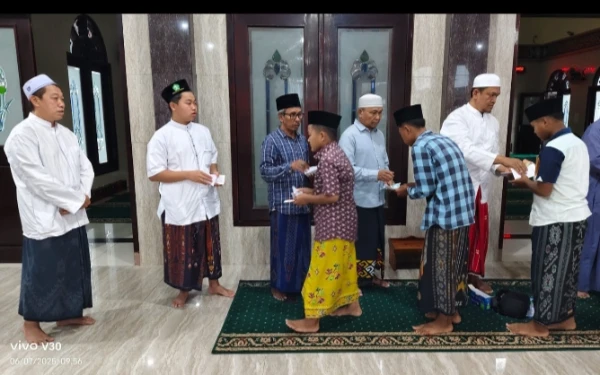 Foto Pengusaha H. Budi Santoso ( kiri ) ikut menyaksikan acara penyerahan santunan yatim dan dhuafa ( Iskandar for KETIK )
