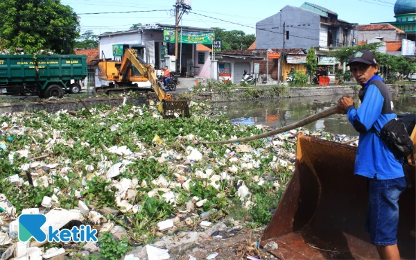 Foto Anggota Satgas Sungai Dinas PU Bina Marga Sidoarjo membantu membersihkan Kali Pelayaran. Mereka mendorong sampah agar mudah diangkat ke dalam truk. (Foto: Fathur Roziq/Ketik)