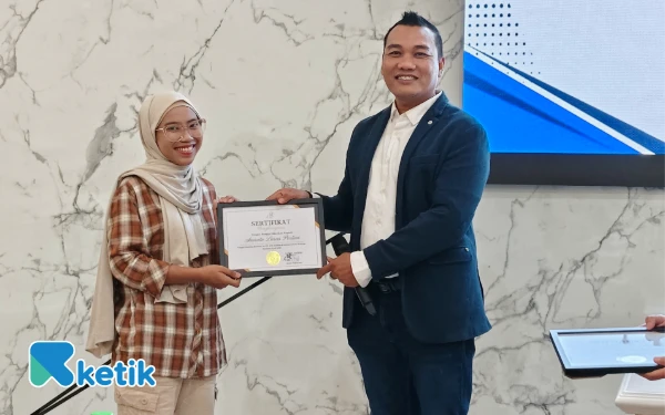 Foto Wakil Ketua ACR Dindin Nor Ali (kanan) memberikan beasiswa kepada Amreta Laras Pertiwi di ruang 204 Gedung FEB, UNAIR, Selasa 8 Juli 2025. (Foto: Fitra/Ketik)