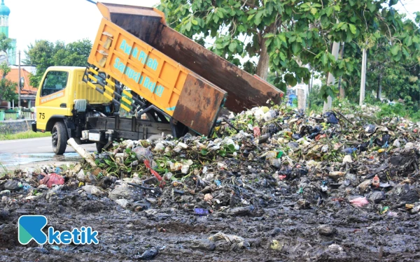 Foto Truk Dinas Lingkungan Hidup dan Kebersihan Sidoarjo menurunkan sampah dari sungai ke tempat pembuangan. (Foto: Fathur Roziq/Ketik.co.id)
