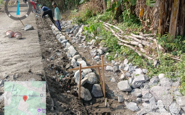 Foto Pekerja terlihat menyusun batu kali langsung di atas tanah tanpa lapisan pondasi dalam proyek TPT di Dusun Bantengan, Desa Tanjunggunung, Jombang.  (dok Kecamatan Peterongan)