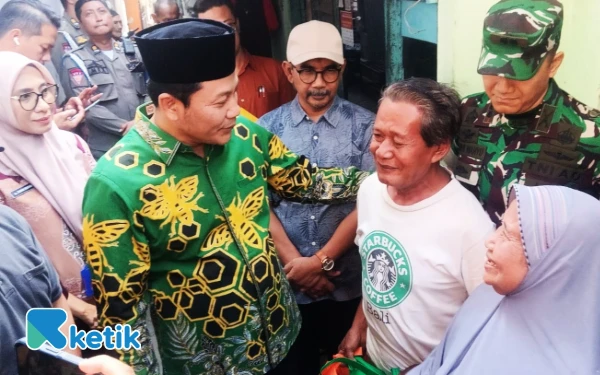 Foto Bupati Sidoarjo Subandi memberikan semangat kepada Madekan dan Munjiati, warga Sidokumpul, Sidoarjo, yang rumahnya rusak parah. (Foto: Fathur Roziq/Ketik)