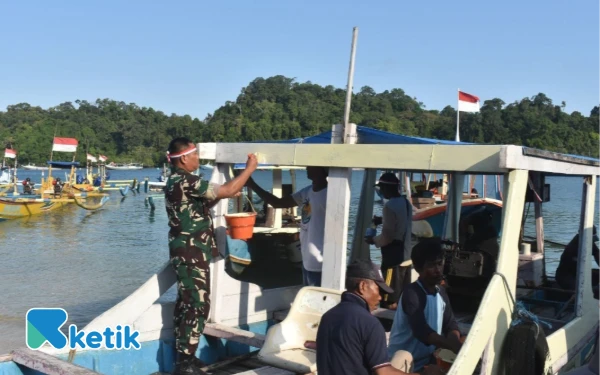 Foto Danrem 083 Kolonel Inf Kohir ketika mengecat perahu nelayan. (Foto: Korem 083 for Ketik)