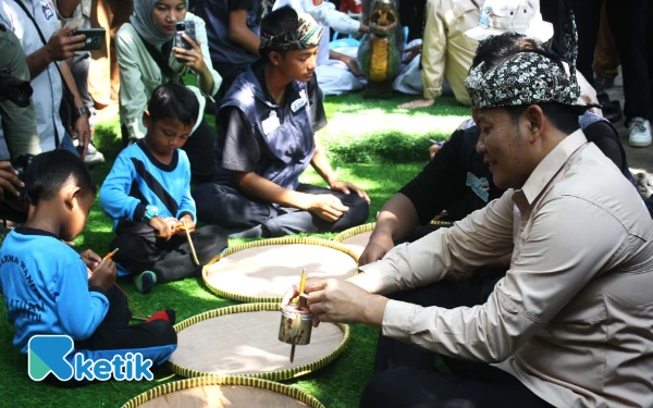 Foto Bupati Sidoarjo Subandi bermain dengan anak-anak di Kampung Lali Gadget, Desa Pagernumbuk, Kecamatan Wonoayu, Sidoarjo, saat peringatan Hari Anak Nasional (HAN) 2025. (Foto: Fathur Roziq/Ketik.com)