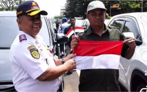 Foto Kadishub Jatim Nyono memberikan bendera merah putih kepada  warga di Bandara Abdulrachman Saleh, Malang.(Foto; Dishub Jatim for Ketik.com).
