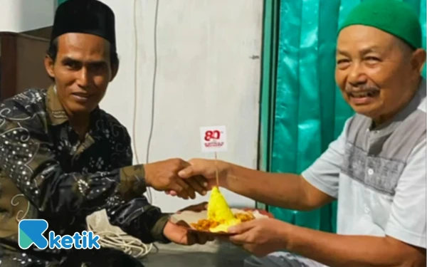 Foto Ketua RT 36, Sukardi bersama Kyai Romdhon Eko juga melakukan potong tumpeng dalam acara tirakatan pada Sabtu, 16 Agustus 2025. (Foto: Angga/Ketik).