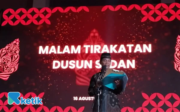 Foto Dukuh Sedan, Miyarno saat membacakan amanat  Bupati Sleman pada acara Malam Tirakatan, Sabtun16 Agustus 2025. (Foto: Bahar/Ketik)