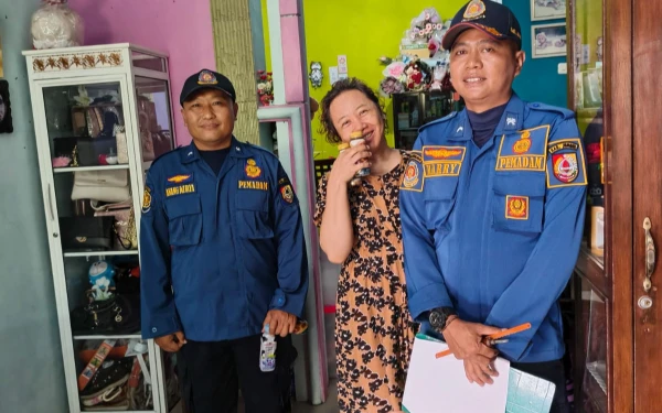 Foto Eli, warga Perumahan Griya Mangli nampak ceria dan berterima kasih usai ditolong petugas Damkarmat Jember. (Istimewa)
