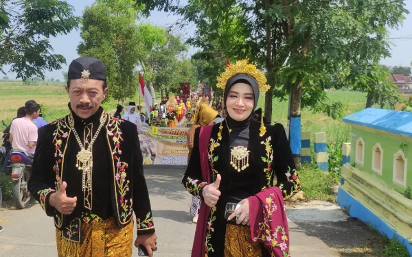 Foto Kepala Desa Tingkis, Agus Susanto bersama istri saat ikut karnaval budaya (24 Agustus 2025)(Foto Ahmad Istihar/Ketik)