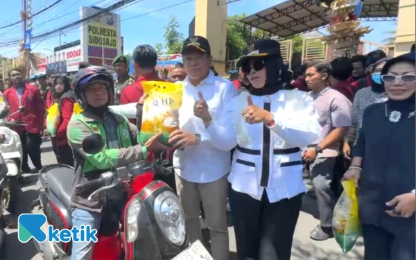 Foto Bupati Sidoarjo Subandi, Wabup Mimik Idayana, dan Sekda Fenny Apridawati bagi-bagi beras kepada tukang becak dan tukang ojek online. (Foto: Ketik.com)