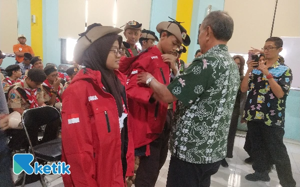 Foto Kepala Dinas Pendidikan Kota Surabaya memakaikan jaket sebagai tanda pemberangkatan peserta ke Jambore Muslim Dunia 2025. (foto: Sutejo Rc/ketik)