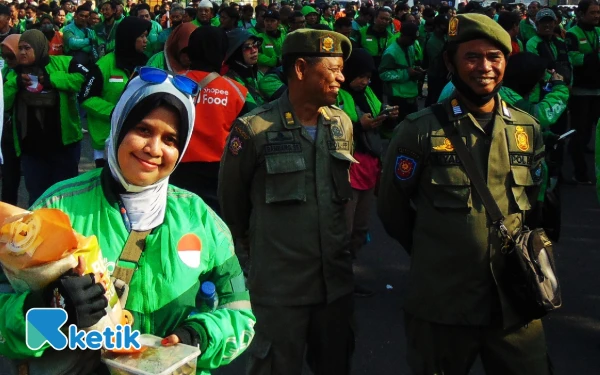 Foto Emak-emak driver online senang mendapatkan 5 kilogram beras dari Pemkab Sidoarjo. (Foto: Fathur Roziq/Ketik.com)
