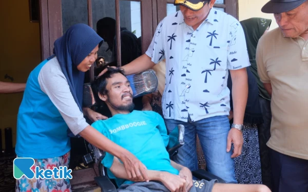 Foto Najih As Sholih tersenyum gembira setelah mendapatkan bantuan kursi roda dari Bupati Subandi. (Foto: Kominfo Sidoarjo)