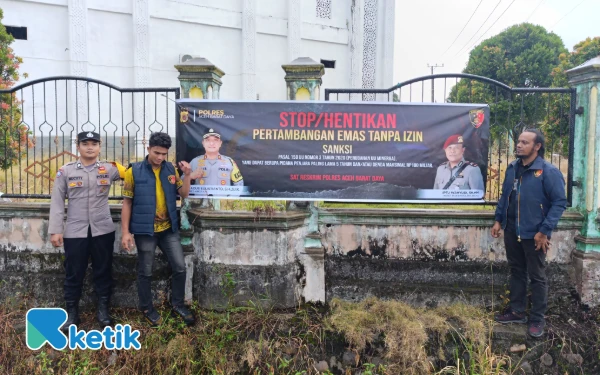 Foto Para personel Sat Reskrim Polres Abdya memasang spanduk imbauan larangan PETI di Ie Mirah, Abdya, Minggu, 28 September 2025. (Foto: T. Rahmat/Ketik)