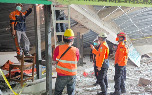 Foto Petugas pencari gabungan memotong konstruksi bangunan ponpes saat evakuasi korban (Basarnas)