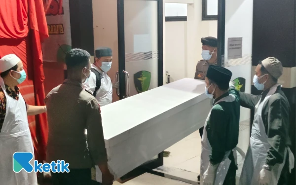 Foto Peti jenazah dibawa petugas ke dalam ruangan sebelum dimasukkan ke dalam ambulans. (Foto: Fitra/Ketik)