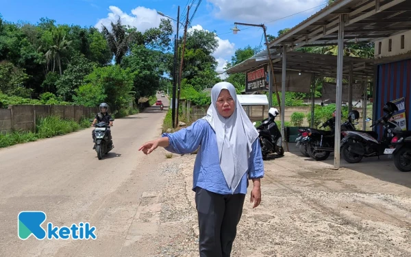 Foto Korban begal, Tetty Yusita (48), menunjuk lokasi tempat ia diserang dua pelaku bersenjata celurit di Jalan Dentjik Asaari, Talang Kelapa, Palembang. Rabu 08 Oktober 2025 (Foto: Yola/Ketik)