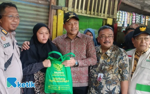 Foto Bupati Subandi memberikan bantuan sembako dari Baznas Sidoarjo dan Dinas Sosial Sidoarjo kepada Mujiana. (Foto: Fathur Roziq/Ketik.com)