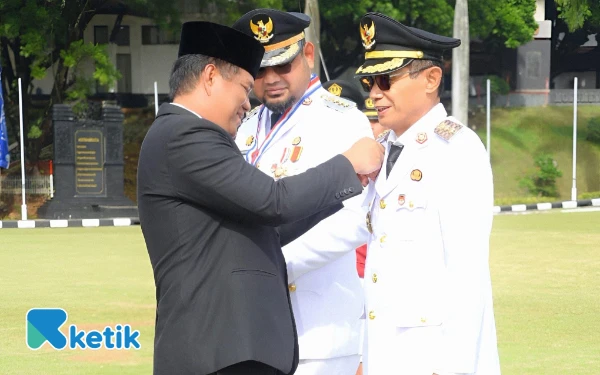 Foto Rektor IPDN Hailul Khairi menyematkan tanda alumni kehormatan kepada Wabup Helmi Umar Muchsin (Foto: Zai For Ketik.com)