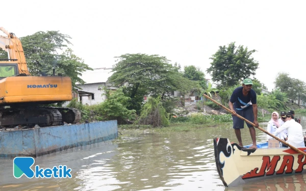 Foto Bupati Subandi naik perahu untuk menyaksikan sendiri kondisi Sungai Mbah Gepuk yang penuh semak belukar dan pepohonan. (Foto: Fathur Roziq/Ketik.com)