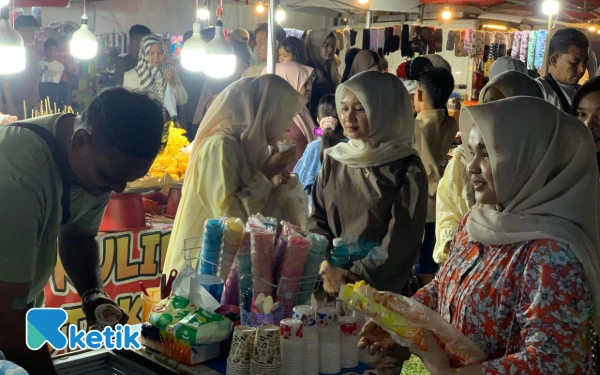 Foto Pengunjung Pagelaran Seni Budaya dan UMKM Expo membeli jajanan es krim dari pedagang, Blangpidie, Sabtu, 1 November 2025. (Foto: T. Rahmat/Ketik)