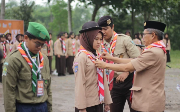 Foto Upacara pembukaan Festival Kebangsaan 2025 Kwarcab Gerakan Pramuka Sleman ditandai dengan penyematan tanda peserta oleh Sekda Sleman Susmiarta, simbol resminya kegiatan yang diikuti 150 peserta tersebut. (Foto: Prokompim Sleman for Ketik.com)