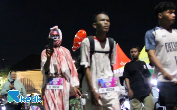 Foto Peserta Gerak Jalan Mojokerto Surabaya menggunakan atribut unik pocong, 15 November 2025. (Foto: Rahmat Rifadin/Ketik.com)