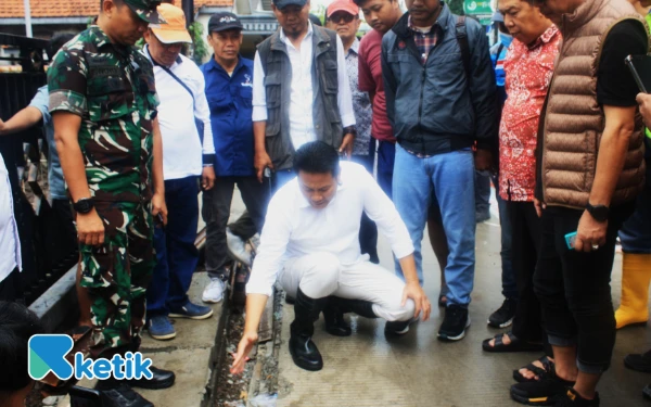 Foto Bupati Sidoarjo Subandi mengamati pinggiran jalan beton yang terlihat protol di Desa Tambak Rejo, Waru, Sidoarjo, pada Sabtu (15 November 2025). (Foto: Fathur Roziq/Ketik.com)