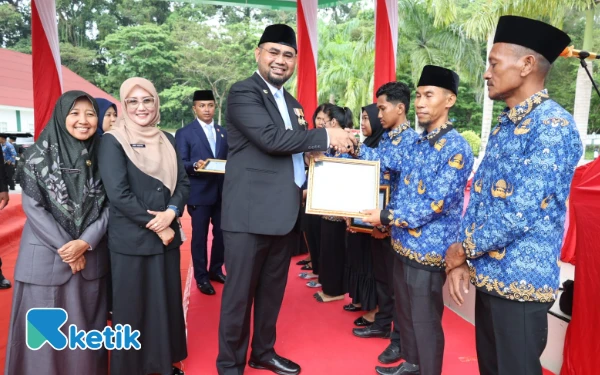 Foto Bupati Bassam menyerahkan piagam penghargaan ke tenaga Nakes (Foto: Mursal/Ketik.com)