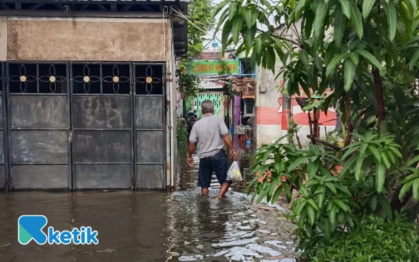 Foto Warga Sidoarjo melintasi genangan banjir, Kamis, 20 November 2025. (Foto: Vio/Ketik.com)