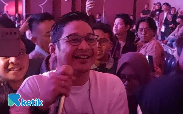Foto Vokalis Ungu, Pasha, menyapa dan bernyanyi langsung di tengah kerumunan penonton, menegaskan momen interaksi tanpa sekat di Yogyakarta. Aksi Pasha yang mendatangi penggemar hingga bagian belakang venue ini disambut antusias dan dimanfaatkan untuk berfoto bersama.  (Foto: Fajar Rianto/Ketik.com)