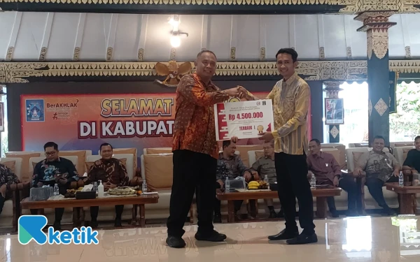 Foto Bupati Sleman, Harda Kiswaya, menyerahkan penghargaan kepada Kalurahan terbaik dalam ajang JDIH Award Kalurahan Tahun 2025 di Pendopo Parasamya, Kamis (27/11). Kalurahan Banyuraden, Gamping berhasil meraih Juara I. (Foto: Fajar Rianto/Ketik.com)
