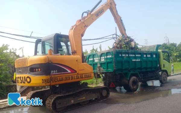Foto Truk-truk DLHK Sidoarjo mengangkut hasil kerukan dari saluran Mangetan Kanal di Kecamatan Gedangan. (Foto: Kominfo Sidoarjo)