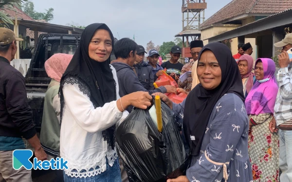Foto Suliyasih (kiri) memberikan bantuan perabotan kepada korban erupsi semeru di Lumajang. (Foto: Rina/Ketik)