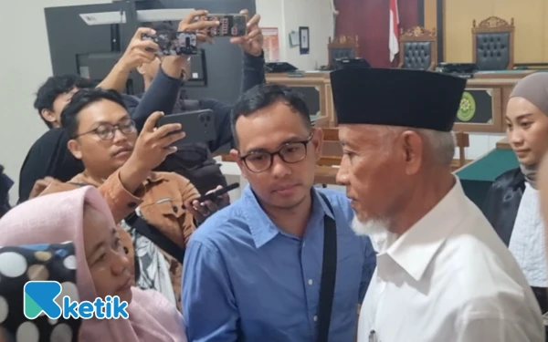 Foto Kustini Sri Purnomo (kiri/jilbab pink) usai menyalami suaminya, terdakwa Sri Purnomo (pakai pecis) setelah menjalani sidang perdana di Pengadilan Tipikor Yogyakarta. Kehadiran Kustini SP menjadi sorotan karena namanya disebut dalam dakwaan jaksa sebagai pihak yang diuntungkan melalui pemenangan Pilkada. (Foto: Fajar Rianto/Ketik.com)