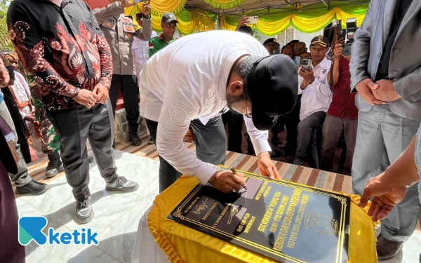 Foto Bupati Bassam Kasuba menandatangani prasasti pembangunan gereja (Foto: Mursal/Ketik.com)