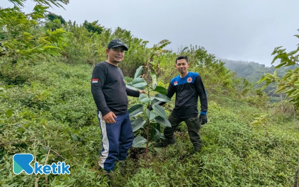 Foto Dua relawan menunjukkan salah satu pohon yang telah ditanam di kawasan Bukit Savana Puncak Tunggangan, Pegunungan Muria. Penanaman ini merupakan bagian dari aksi reboisasi Gerakan Peduli Muria untuk memulihkan fungsi hutan dan menjaga keberlanjutan sumber mata air di kawasan pegunungan, Minggu (21/12/2025) (Foto: Malik Naharul/Ketik.com).