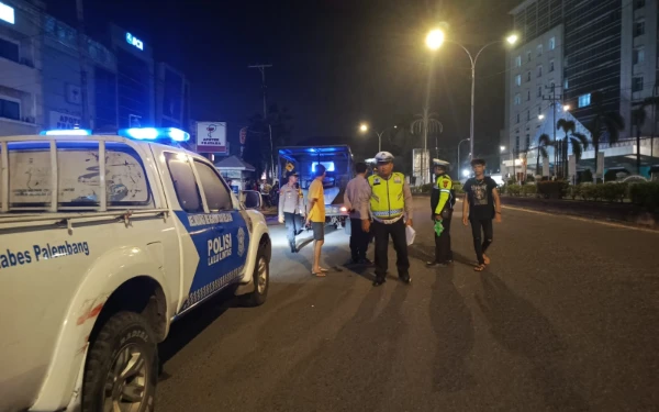 Foto Anggota Satlantas Polrestabes Palembang melakukan olah TKP dan menghimpun keterangan saksi di lokasi kecelakaan yang terjadi di Jalan Jenderal Sudirman depan Bank BSI, pada Senin (22 Desember 2025) dinihari (Foto : Yola/Ketik.Com)