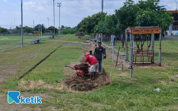 Foto Aktivitas pengerjaan di sisi barat Stadion Forlantas, Sidomoyo, Godean, Sabtu siang, 20 Desember 2025 pekan lalu. Terlihat pekerja sedang melakukan penggalian jalur dan penyiapan lahan untuk pemasangan pembatas beton (kanstin) serta penataan paving blok guna mengejar target penyelesaian proyek jogging track di akhir tahun anggaran. (Foto: Fajar Rianto/Ketik.com)