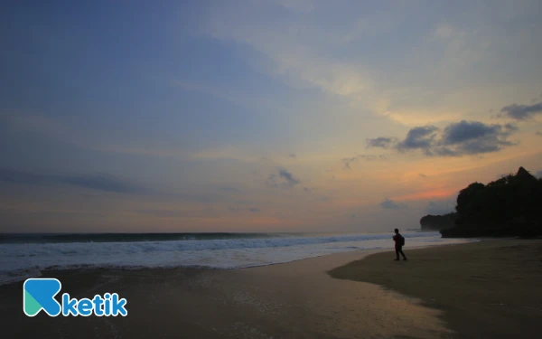Foto Seorang wisatawan tengah menikmati sunset di Pantai Nganteb. (Foto: Fisca/Ketik.com)