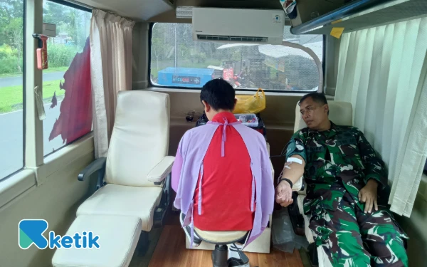 Foto Danramil 0833/02 Kedungkandang, Kapten Chb Arif Suteja sedang melakukan donor darah di Apotek Slamet Urip. (Foto: Aliyah/Ketik.com)