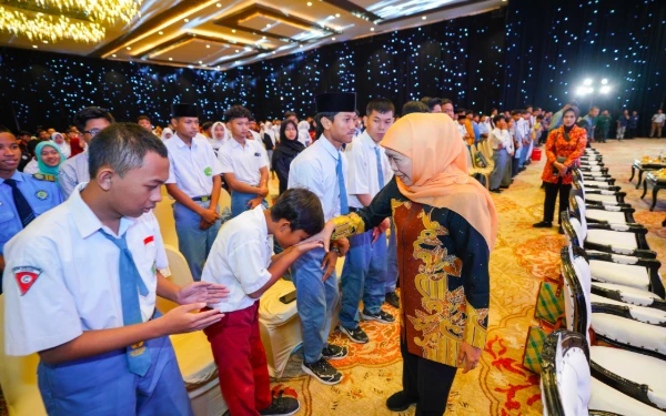 Foto Seorang siswa mencium tangan Gubernur Jatim Khofifah Indar Parawansa di sela peluncuran program bantuan biaya pendidikan di Surabaya beberapa waktu lalu. (Foto: Biro Adpim Setdaprov Jatim)