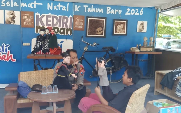Foto Kapolsek Kediri Kota, AKP Bowo Wicaksono tampak menghibur seorang anak pengunjung dengan memainkan wayang golek, Senin (29/12/2025). (Foto : AKP Bowo for Ketik).