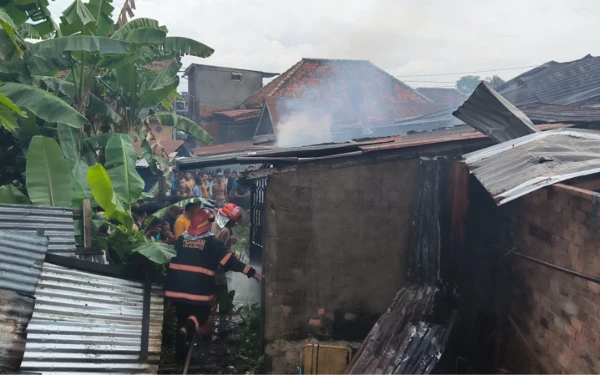 Foto Petugas pemadam kebakaran saat melakukan pemadaman api di sebuah rumah di Jalan Ki Gede Ing Suro, Lorong Sungai Tawar, Kecamatan Ilir Barat 2, Palembang , Senin 29 Desember 2025 (Foto : Yola/Ketik.Com)