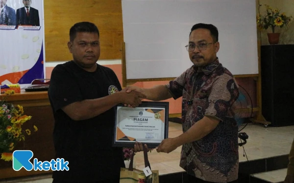 Foto Farid Husen Menyerahkan piagam penghargaan bagi salah satu wajib pajak patuh (Foto: Mursal/Ketik.com)