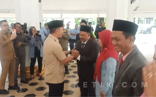 Foto Bupati Lebak, Moch. Hasbi Asyidiki Jayabaya saat memberikan selamat kepada Direktur Perumdam Tirta Kalimaya, Ni'kmatullah. (Foto: Abdul Kohar)