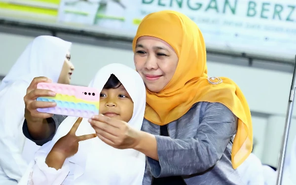Foto Gubernur Jatim Khofifah Indar Parawansa (kanan) berswa foto bersama seorang anak perempuan di Kabupaten Gresik beberapa waktu lalu. (Foto: Biro Adpim Setdaprov Jatim)
